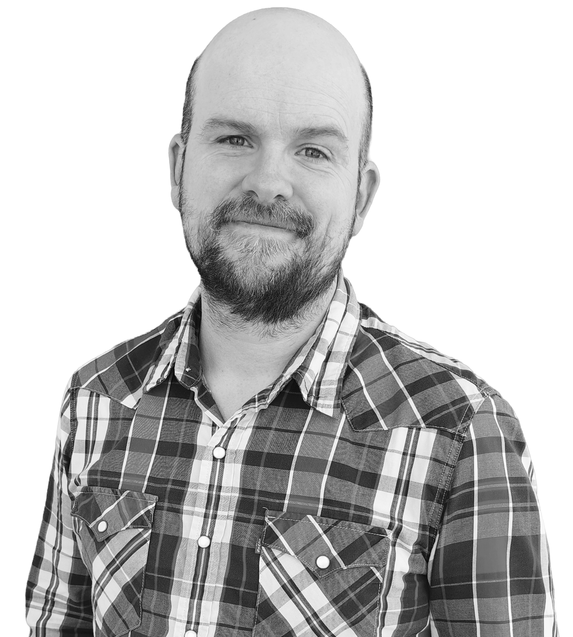 Monochrome headshot of Travis Peterson, a bald man with a short beard wearing a plaid shirt and smiling